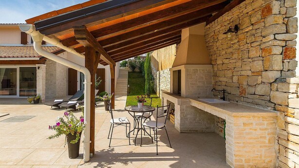 An outdoor patio with a stone wall, a pergola, and a built-in barbecue area. - Amazing home in Labin - Rabac (Labin - Rabac)