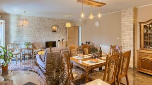 A dining area with a brick wall, wooden furniture, and a chandelier. - Cozy home in Pazin with WiFi (Pazin)