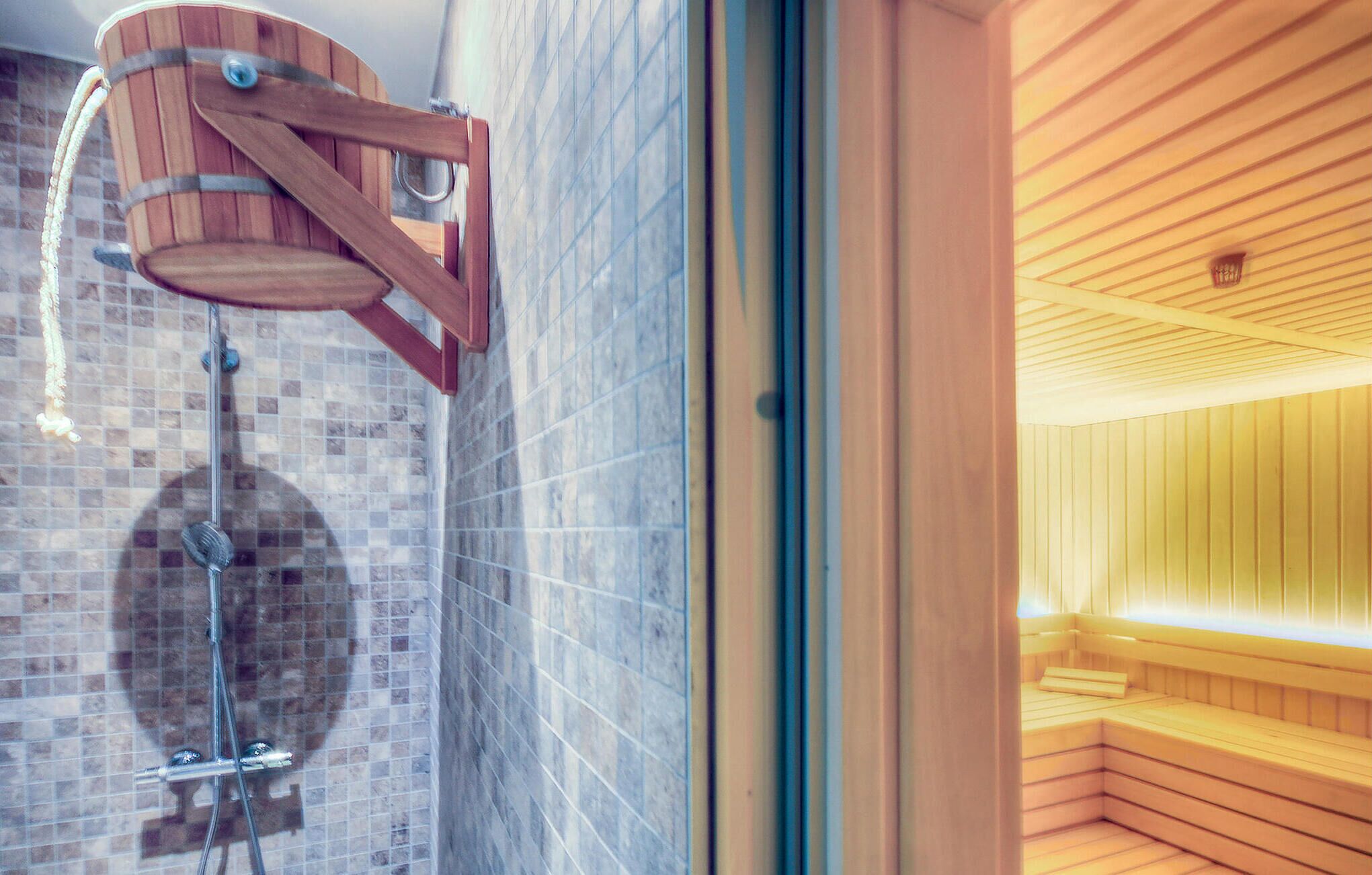 Una sauna con panche in legno e parete rivestita di piastrelle.
