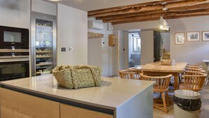 Eine moderne Küche mit eingebauten Geräten, einer zentralen Kochinsel und einem Essbereich mit Holzkästen.