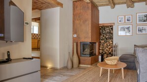 Ein Wohnzimmer mit Kamin, Fernseher und einer Couch.