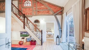 A spacious interior with a wooden staircase, a large window with curtains, and a dining area with a table set for two. - Awesome home in Ausacker with WiFi (Ausacker)