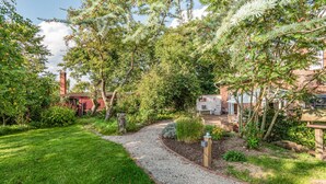 A garden pathway leading to a patio area with outdoor seating. - Awesome home in Ausacker with WiFi (Ausacker)