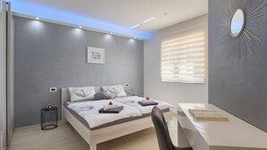 Ein modernes Schlafzimmer mit Bett, Nachttisch und Schreibtisch.