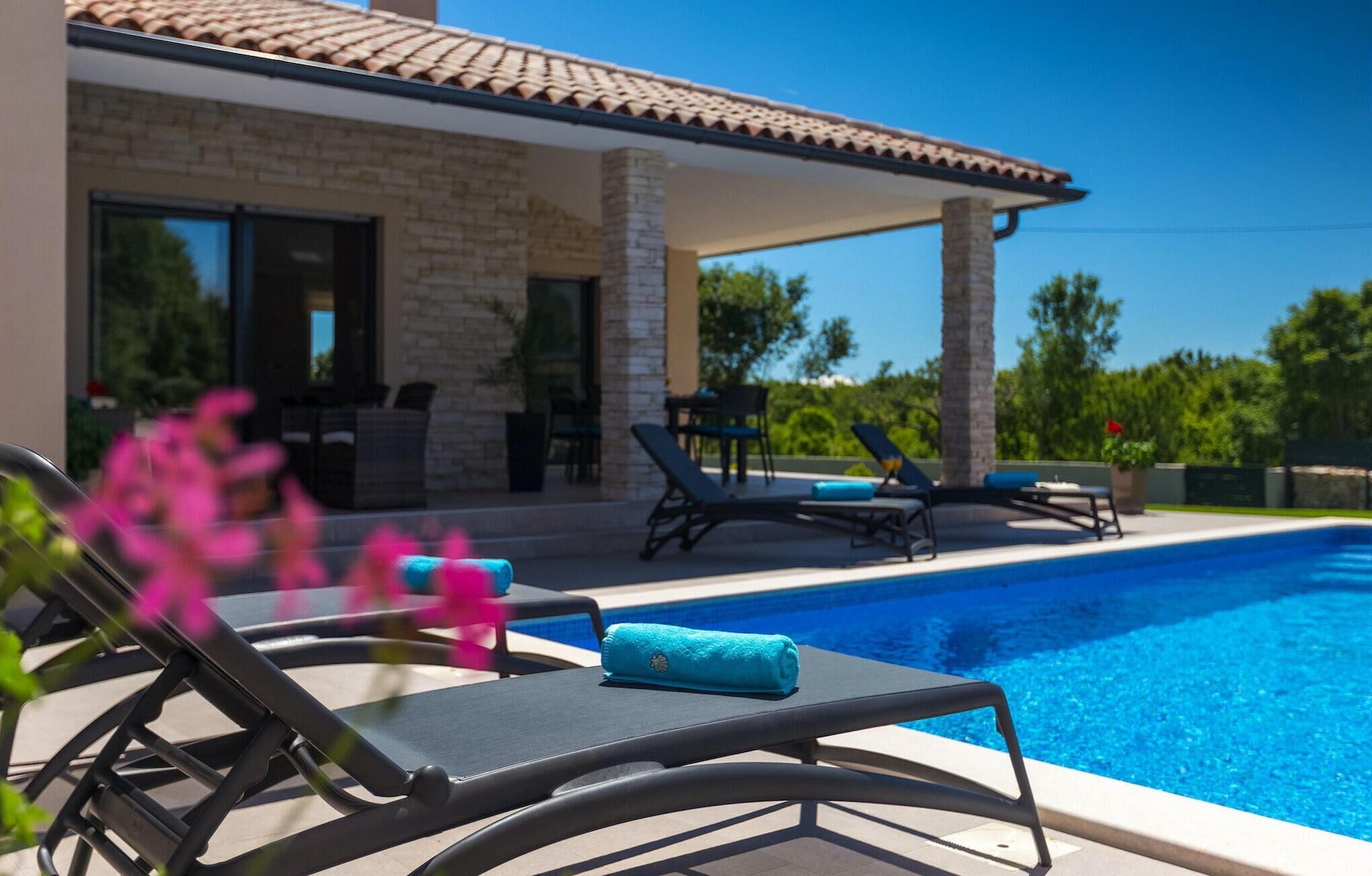 A poolside area with lounge chairs and a covered patio.