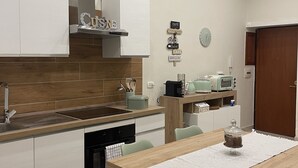 Eine moderne Küche mit weißen Schränken, einer Holzarbeitsplatte und einem Essbereich mit Tisch und Stühlen.
