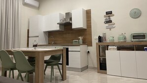 Eine moderne Küche mit weißen Schränken, einer Holzarbeitsplatte und einem Essbereich mit Tisch und Stühlen.