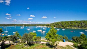 A marina with numerous boats docked, surrounded by lush greenery and a clear blue sky. - Gorgeous home in Pula (Pula)