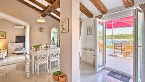 A modern interior with a dining area, a kitchen, and a balcony with a view of the sea. - Gorgeous home in Pula (Pula)
