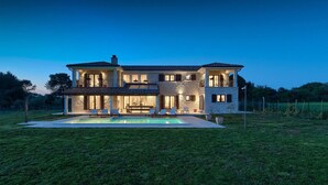 Une maison à deux étages avec une piscine située dans le jardin avant.