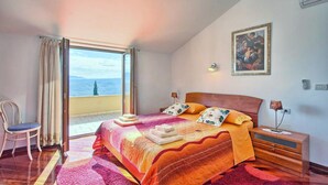 A bedroom with a large bed, a chair, a nightstand, and a painting on the wall. - Awesome home in Pican (Pican)