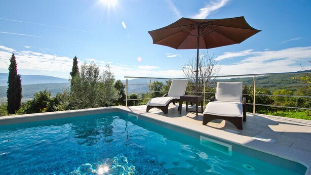 A swimming pool with two lounge chairs and an umbrella, surrounded by a glass railing with a scenic view. - Awesome home in Pican (Pican)