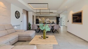 Un salon moderne comprenant un canapé, une table basse et un coin repas avec des chaises et une table.