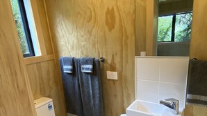 Een kleine badkamer met toilet, wastafel en raam.