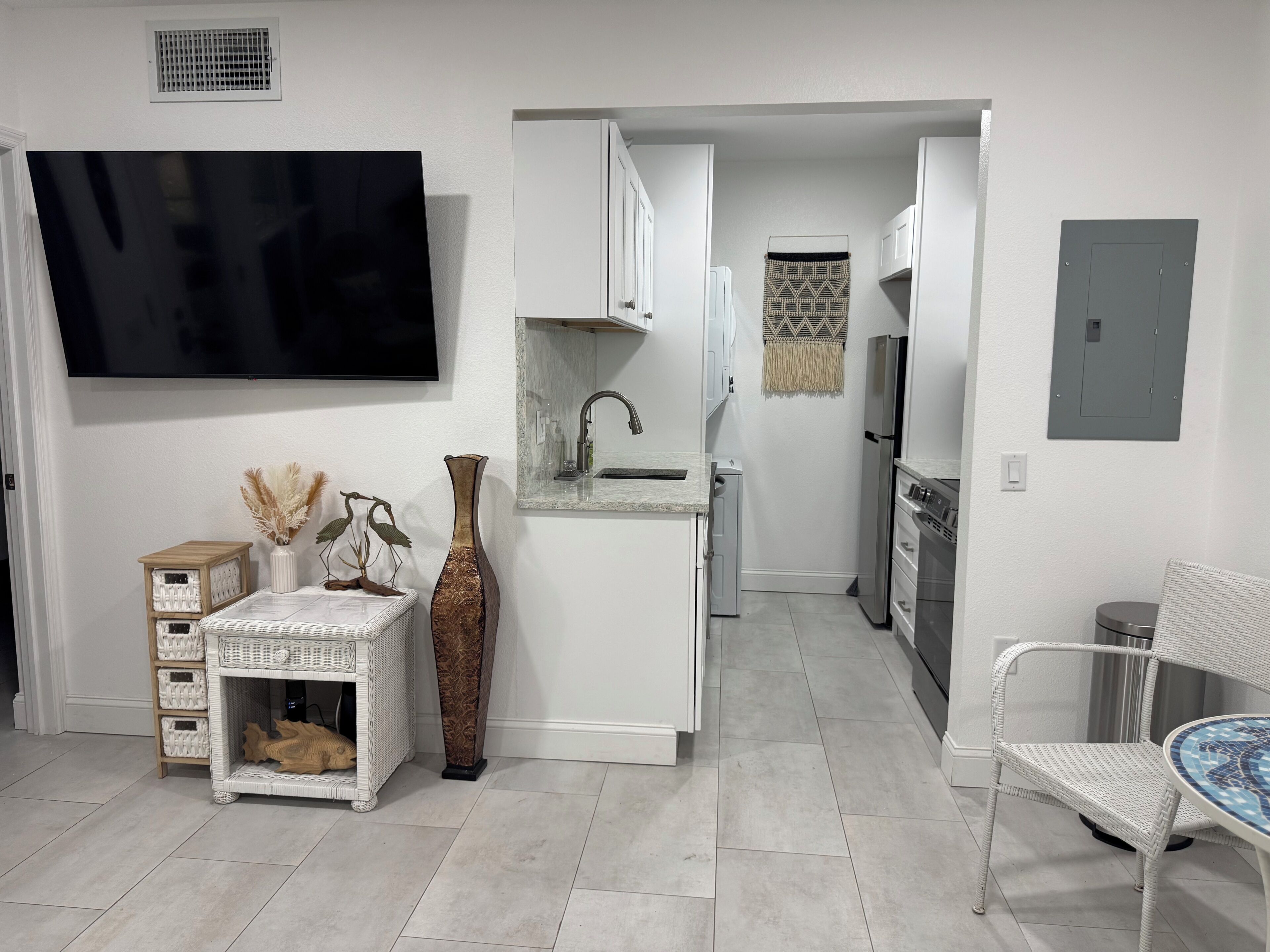 A modern kitchen with white cabinetry, a built-in sink, and a stainless steel refrigerator.