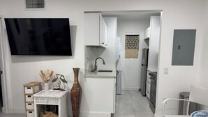 A modern kitchen with white cabinetry, a built-in sink, and a stainless steel refrigerator. - Beachy Boho. August specials Waterfront Building 1st Floor, 1 Block to Beach (Madeira Beach)