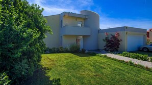 A modern two-story house with a flat roof, a cylindrical water tank, and a well-maintained lawn. - Amazing home in Kostrena with sauna (Kostrena)