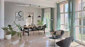 Uma sala de jantar moderna com uma mesa de madeira, cadeiras pretas e um vaso com planta.