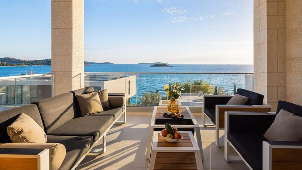 A balcony with a view of the sea, furnished with sofas and a table with fruit. - Beautiful home in Rogoznica with sauna (Rogoznica)