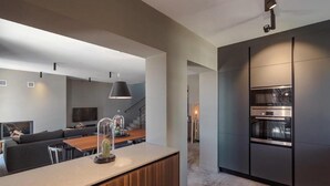 A modern kitchen with dark cabinetry and stainless steel appliances. - Awesome home in Porec (Porec)