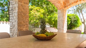 A table with a woven basket containing a pineapple, bananas, and grapes. - Pet friendly home in Pula (Pula)