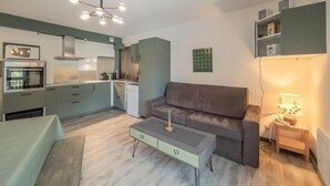 Un appartement moderne comprenant un coin cuisine, un espace repas et un salon.