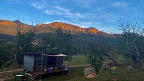 A modern cabin with a deck, surrounded by a mountainous landscape. - The Nile Farmstay - Cabin with cliff views, hiking trails, heated spa (Upper Nile)