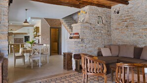 A rustic interior with a stone wall, wooden furniture, a staircase, and a dining area. - Pet friendly home in Barban (Barban)