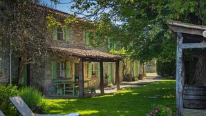A stone building with a tiled roof, green shutters, and a covered patio area. - Stunning home in Buzet (Buzet)