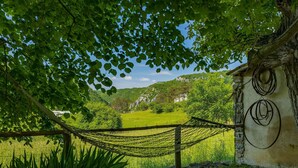 A rustic building with a stone wall and a hammock strung between trees. - Stunning home in Buzet (Buzet)