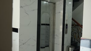 A modern elevator with marble walls and a sleek design. - SoursdeiSawadeeBoutique (Kampot)