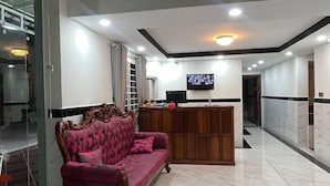 A spacious lobby with a marble floor, a reception desk, and a pink sofa. - SoursdeiSawadeeBoutique (Kampot)