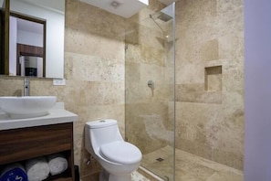 Ein Badezimmer mit einem weißen Waschbecken, einer Toilette und einer Duschkabine.