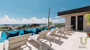 A rooftop pool area with lounge chairs and a view of the ocean. - Stylish Studios Pool Near Beach (Playa del Carmen)