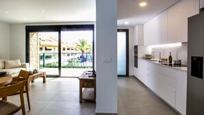 Una cocina moderna con armarios blancos, horno empotrado y una encimera con un tostador.