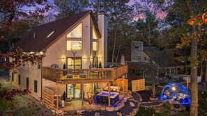 A two-story house with a balcony, a hot tub, and a deck area. - Lakefront - GeoDome, Kayaks, Hot Tub, Fire Pits, Swingset, Game Room, Theater,EV (Tobyhanna)