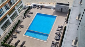 A rooftop pool with lounge chairs and a small building structure. - Chic Studio in The Signature, Accra (Accra)