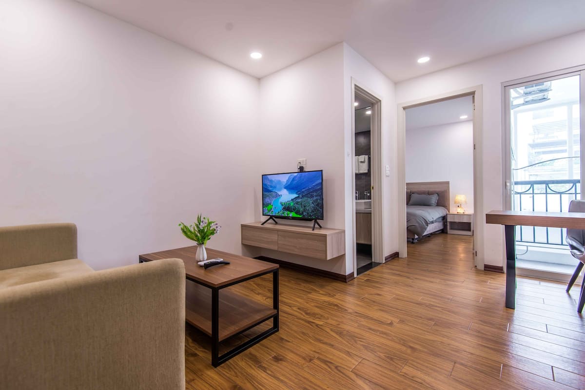 Ein modernes Wohnzimmer mit Flachbildfernseher, Couchtisch und Sofa.