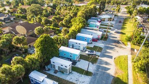 Una fila de casas móviles con entrada pavimentada y vegetación circundante.
