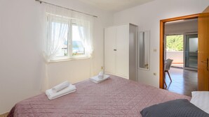 A bedroom with a bed, a wardrobe, a window with sheer curtains, and a door leading to a balcony. - Nice apartment in Klek with WiFi (Klek)