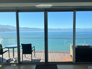 Uma varanda com vista para o oceano e montanhas.