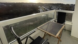 A balcony with a view of a parking lot and buildings in the distance. - Studioapartment in der Frische Brise 04.05 - Frische Brise (Cuxhaven)