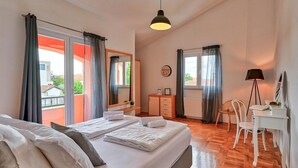Un dormitorio con cama, escritorio, silla y ventana.