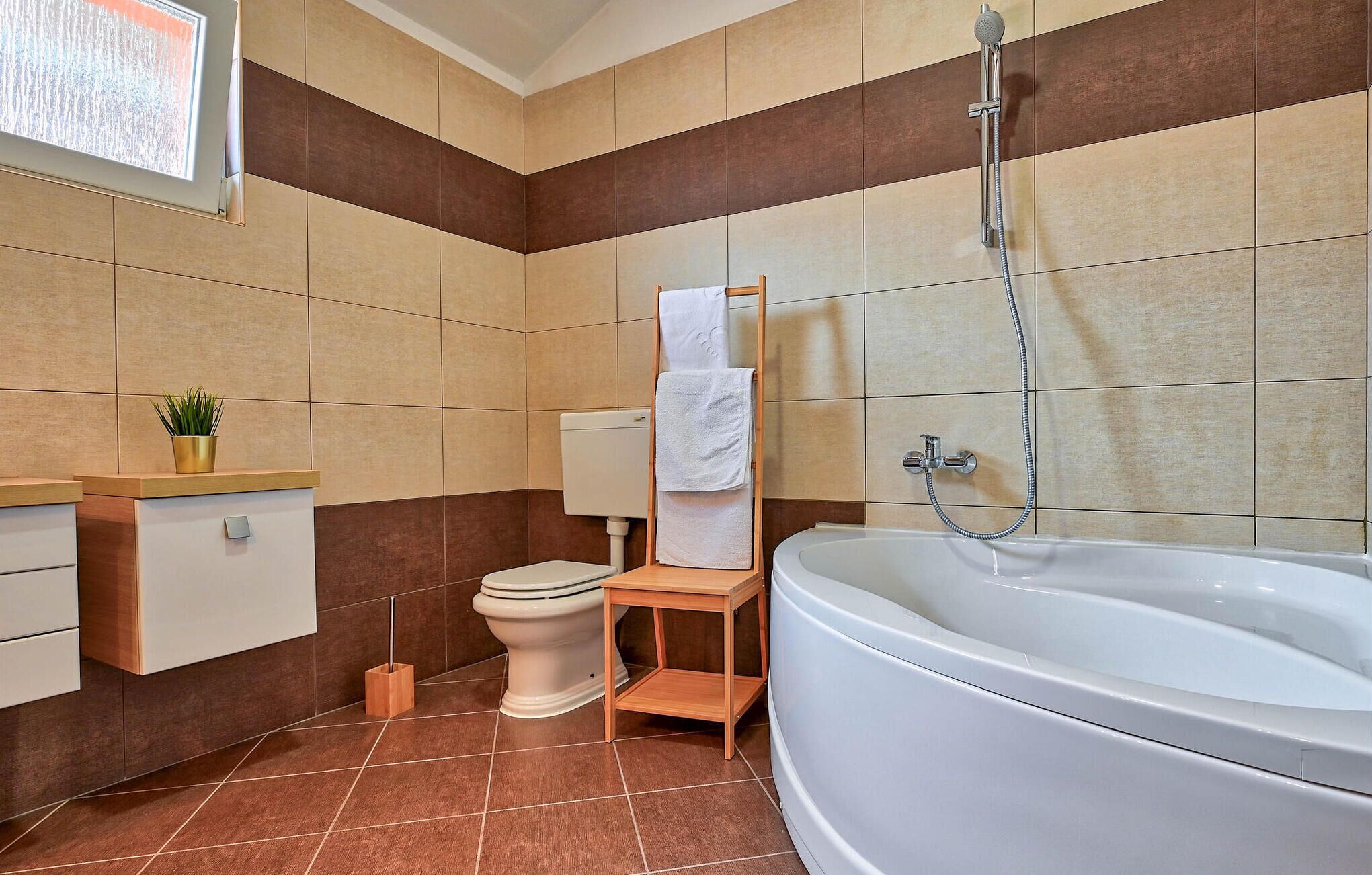Une salle de bain moderne équipée d’une baignoire, de toilettes et d’un porte-serviettes.
