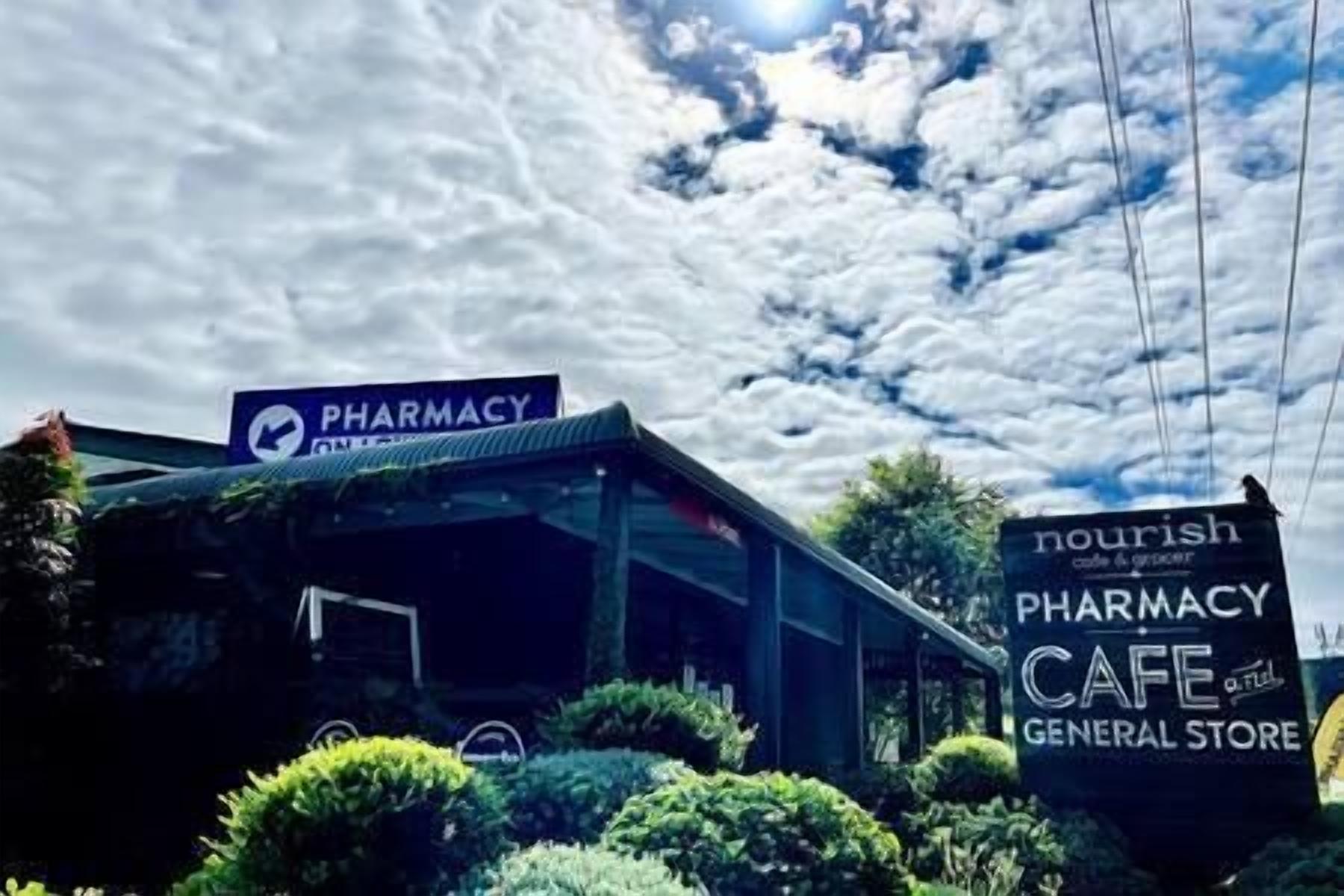 A pharmacy with a cafe and general store sign.