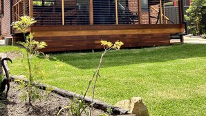 A modern house with a covered porch, brick walls, and large windows. - The Bungalow - Luxurious & Calm | Beach & Bush (Valla Beach)