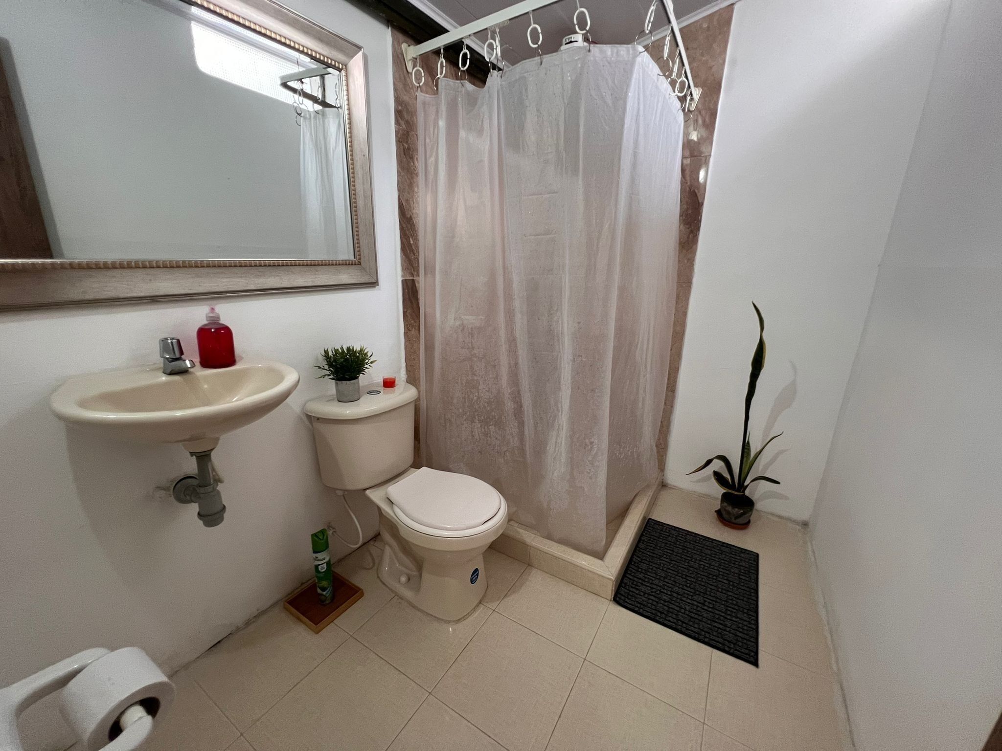 Une petite salle de bain avec des toilettes, un lavabo et un rideau de douche.