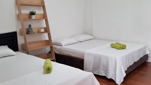 A room with two beds, a wooden ladder, and a small shelf with a plant and a figurine.