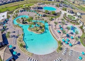 Un resort con varias piscinas, tumbonas y palmeras.