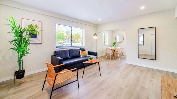 A modern living room with a sofa, a coffee table, and a dining area.